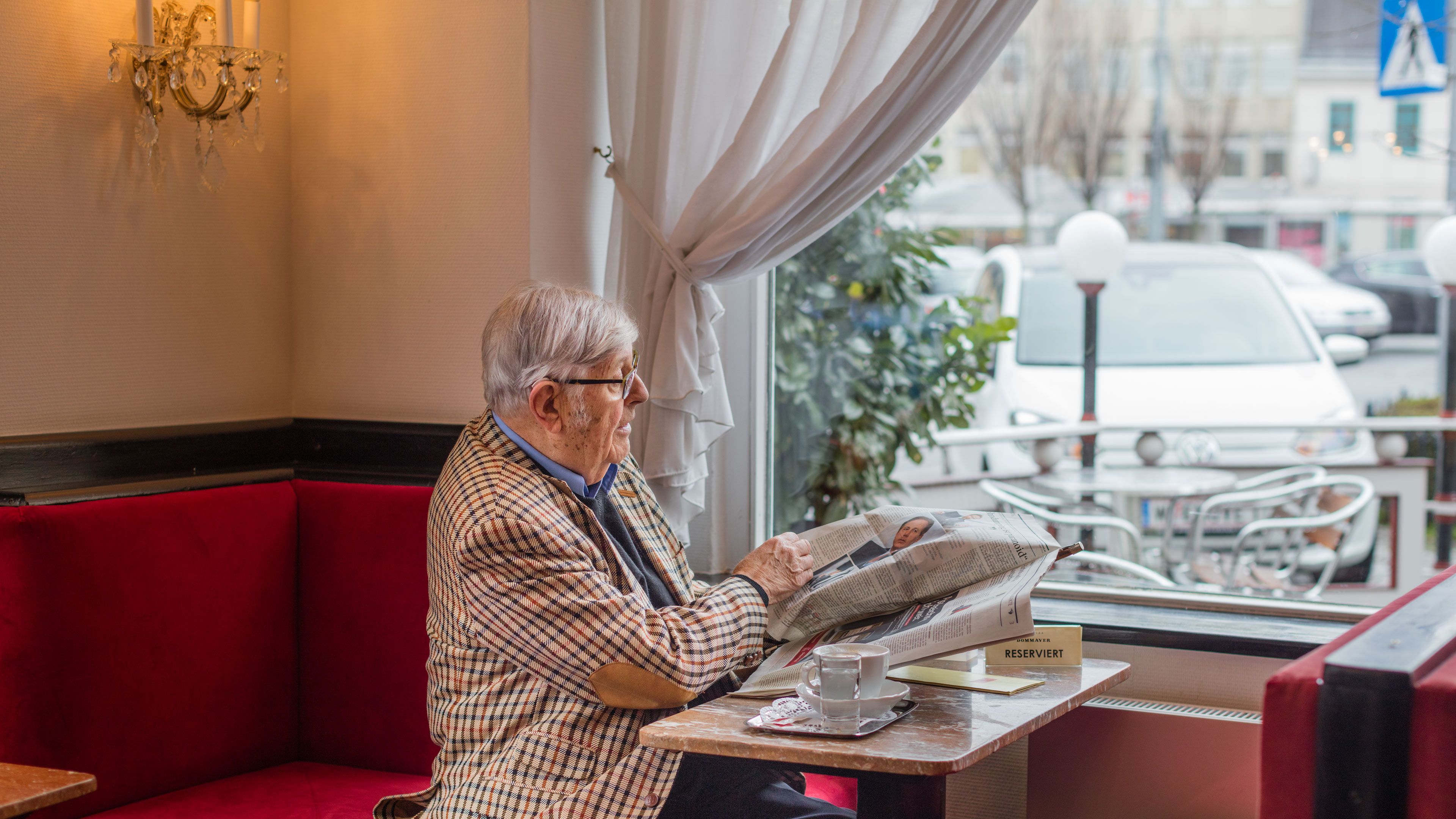 Heinz Gerhard sitzt im Café Dommayer am Fenster und schaut auf seinen e-up!