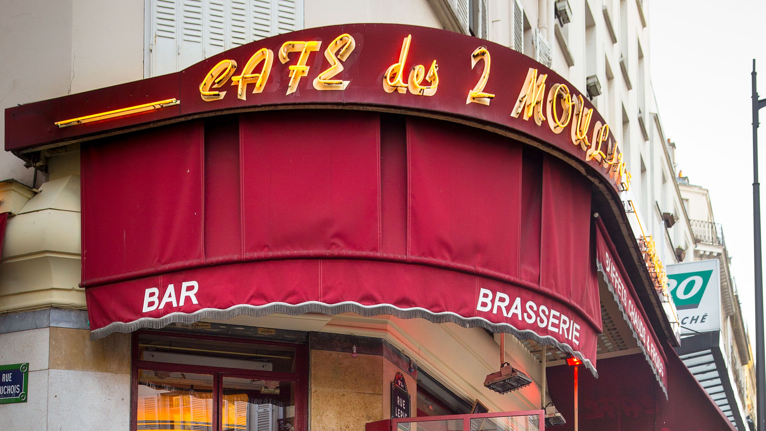 Alexandre Marie sitzt vor einem Café, sein e-up! ist neben ihm geparkt